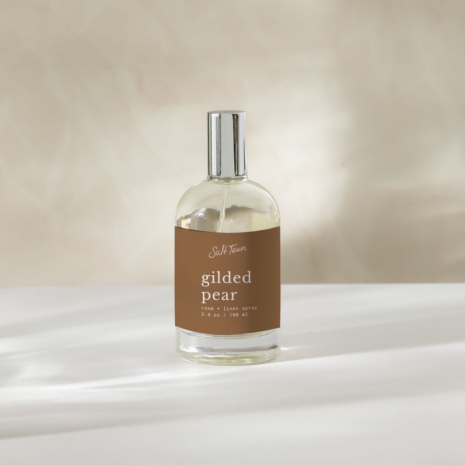clear glass bottle with gilded pear room spray label