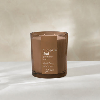 Coco colored glass candle vessel with pumpkin chai on the label. 